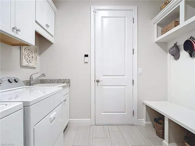Laundry area featuring cabinet space, laundry sink, separate washer and drop zone.