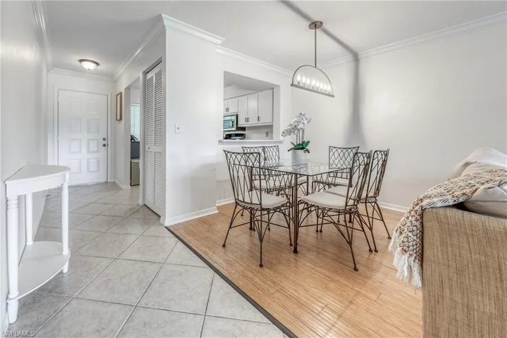 Dining room featuring a chandelier, light tile floors, and crown molding