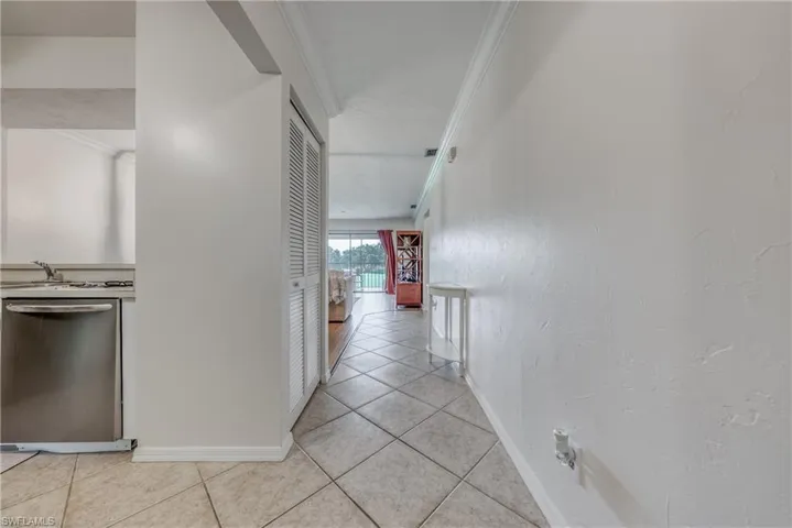 Hall featuring ornamental molding and light tile flooring
