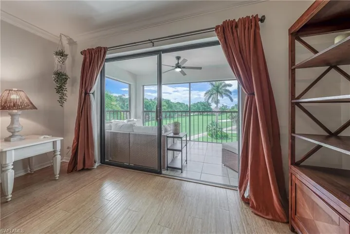 Doorway with crown molding, light wood-type flooring, and ceiling fan