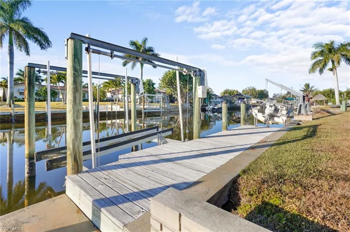 Dock area featuring boat lift, boat dock and concrete seawall provides you direct boating access to the Caloosahatchee River and Gulf.