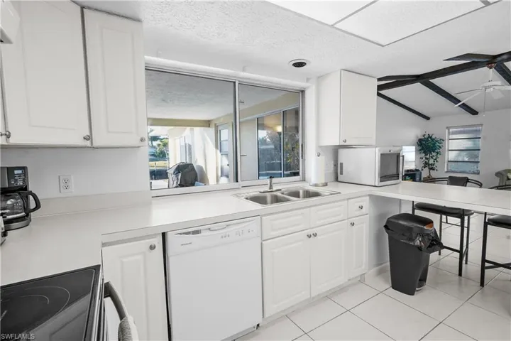 Great layout for entertaianing! The Kitchen features a large window that slides into wall pocket to allow for for the window to completely open giving full pass thru access to the pool. Snack bar / peninsuala opens to the family room.