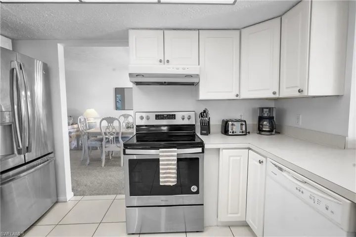 Kitchen featuring stainless steel appliances, white cabinets, light neutral colored finishes for flexible decorating.