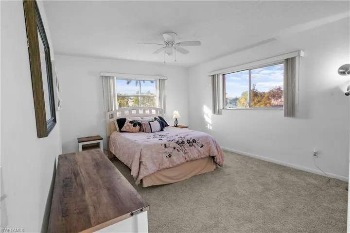 Guest Bedroom #2 featuring carpet floors, multiple windows with window coverings a ceiling fan and large closet.