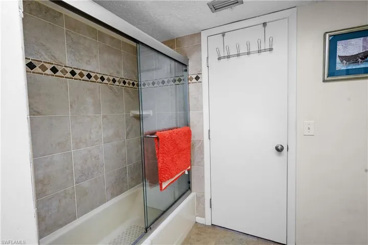 Guest wing / pool access full bathroom with bath / shower combo with glass door..