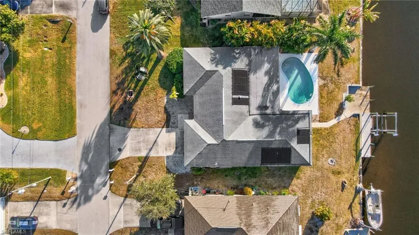 Aerial view of newer roof, a solar heated pool, boat dock and boat lift. Easy access from the home to the dock.