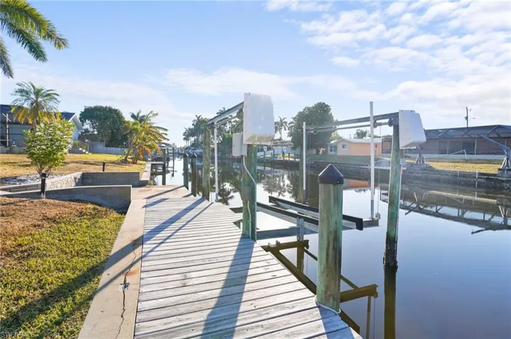 Dock area featuring boat lift and a water view