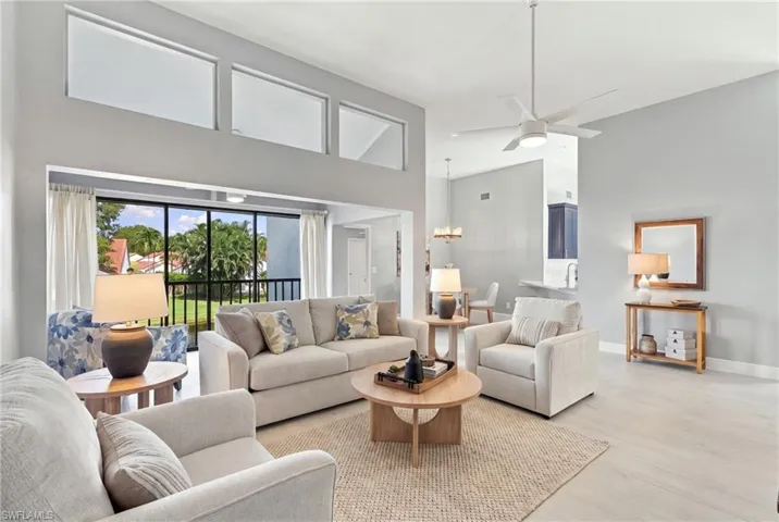 Vaulted ceilings with clerestory windows, wood-finish flooring, and expansive sliding glass doors