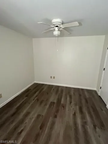 Unfurnished room with ceiling fan and dark hardwood / wood-style floors