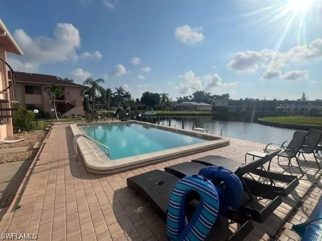 View of pool with a water view and a patio area