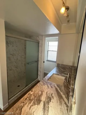 Bathroom featuring vanity, hardwood / wood-style flooring, and a shower with door