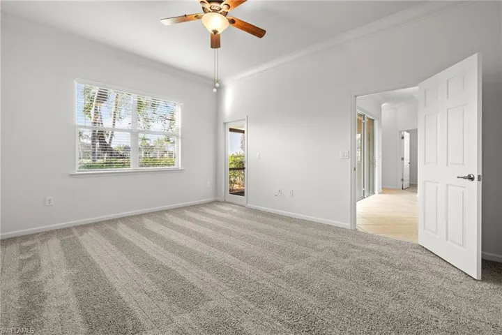 Carpeted spare room featuring crown molding and ceiling fan