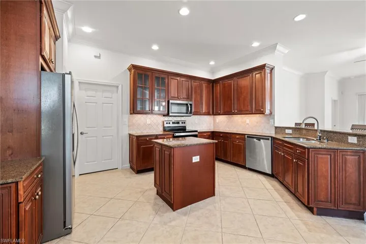 Kitchen featuring sink, a center island, granite countertops, kitchen peninsula, and stainless steel appliances