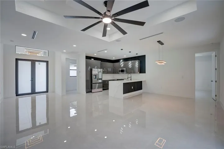 Unfurnished living room with a ceiling fan, recessed lighting, and french doors