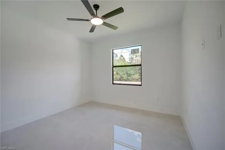 Unfurnished room featuring baseboards and a ceiling fan