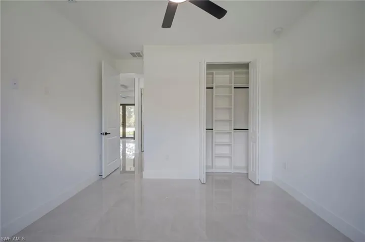 Unfurnished bedroom with a ceiling fan and a closet