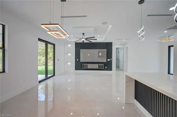 Unfurnished living room featuring a ceiling fan and recessed lighting