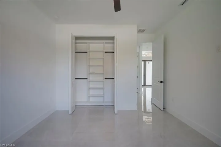 Unfurnished bedroom with a ceiling fan and a closet