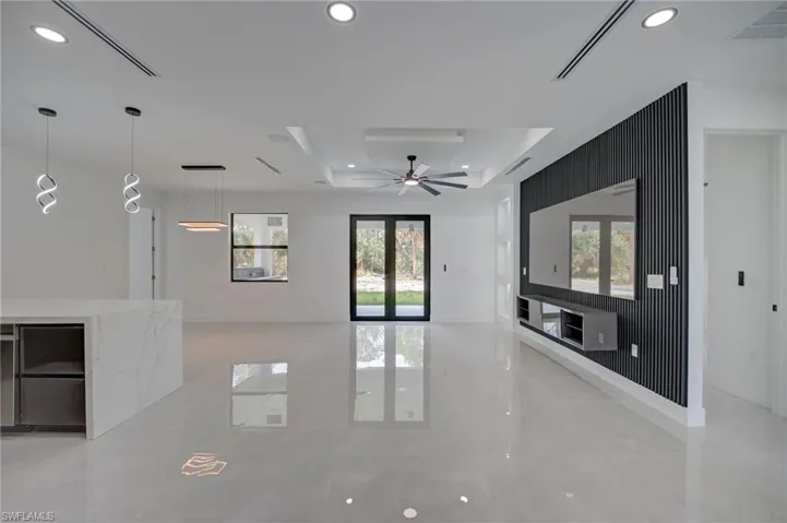 Unfurnished living room featuring recessed lighting, a tray ceiling, and ceiling fan