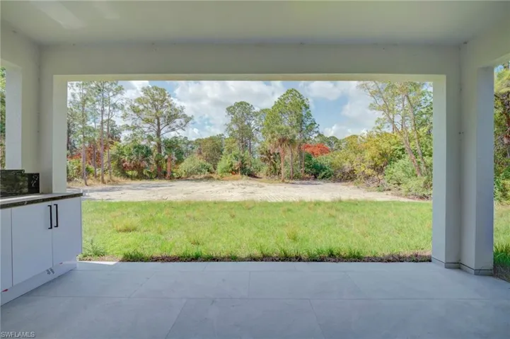 View of grassy yard with a patio area