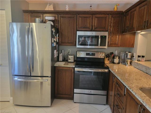 Stainless steel appliances, granite counter with pass through to snack bar and dining room
