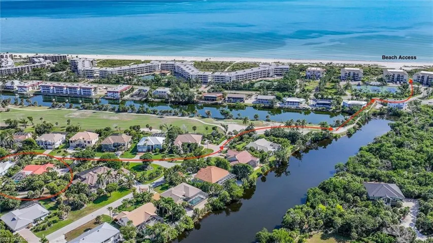 Aerial perspective of coastal residential property featuring proximity to water, mature vegetation, and designated walking path providing direct access to the beach
