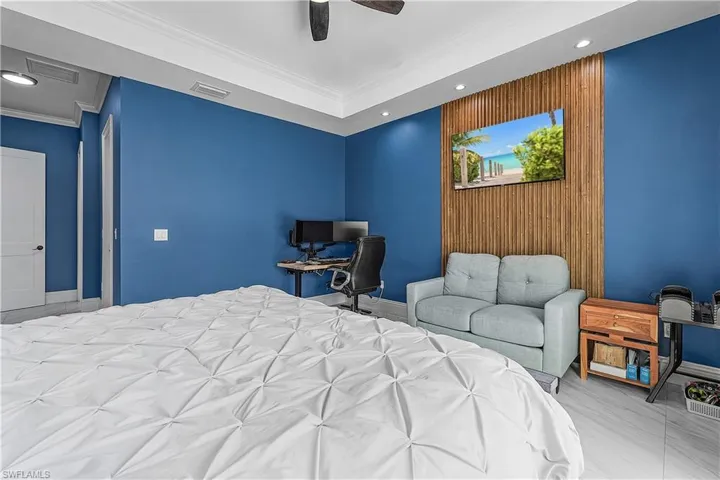 Primary bedroom with an accent wall, recessed lighting, a ceiling fan, and crown molding