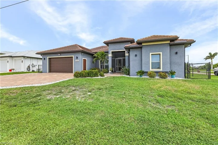 Front of home featuring stucco siding, decorative driveway, a garage, and a screened porch
