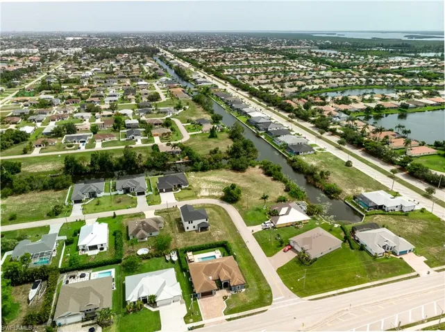 Aerial view of property and surrounding area featuring nearby suburban area