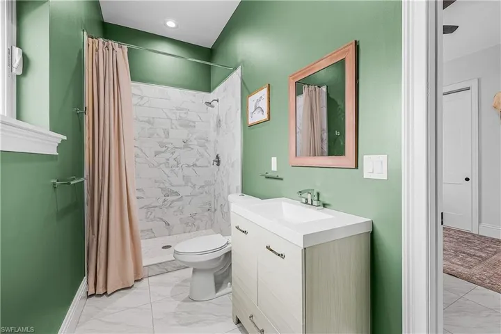 Full bath featuring vanity, light flooring, and a shower