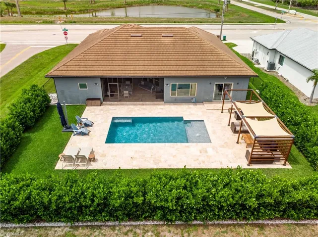 Back of property with a patio, pool, and lawn