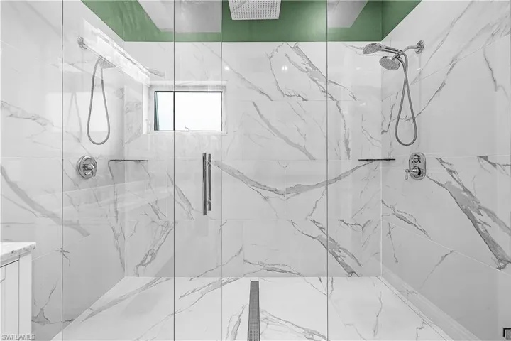Full bath with a marble finish shower
