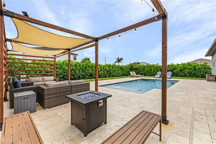 Outdoor pool featuring a patio area and an outdoor living space with a fire pit