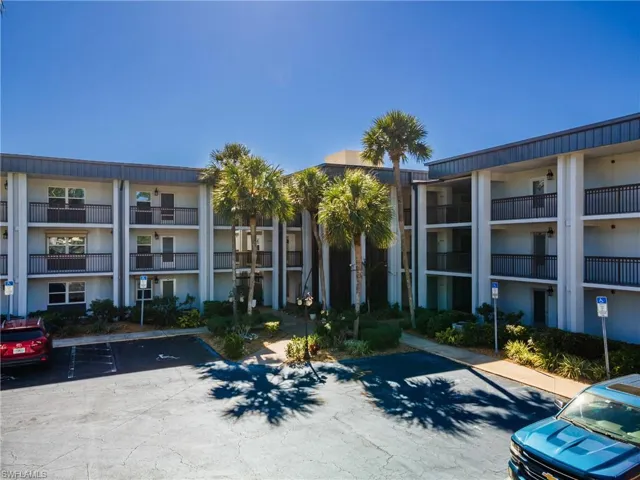 View of apartment building / complex featuring uncovered parking