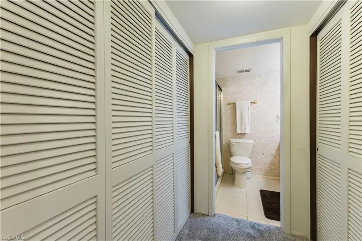 Corridor with light tile patterned flooring and wallpapered walls