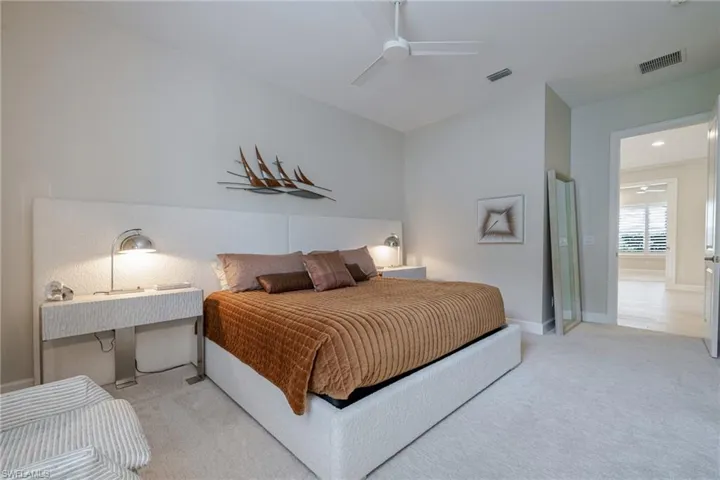 Bedroom with light colored carpet and ceiling fan