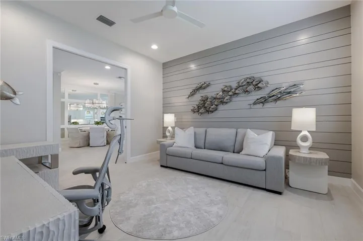 Office with wood walls, an accent wall, a chandelier, recessed lighting, and light wood-style floors