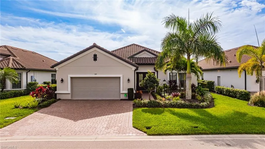 Mediterranean / spanish-style home with stucco siding, a front yard, decorative driveway, and an attached garage