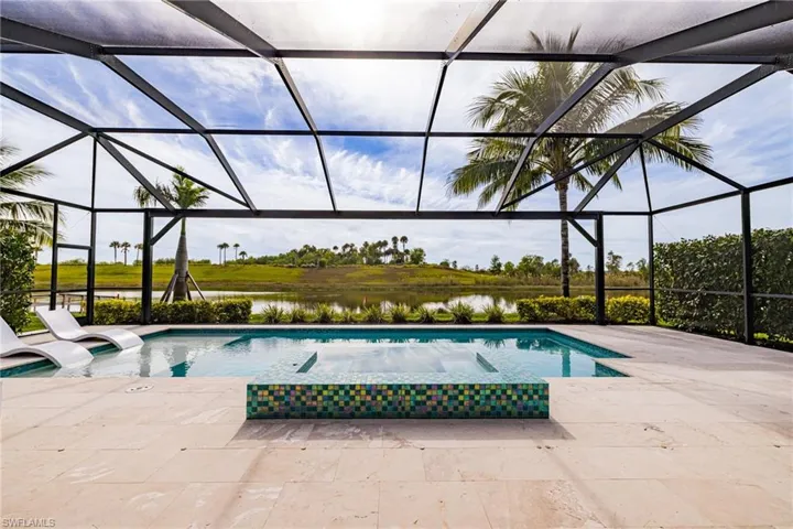 Swimming pool with a sunroom, a water view, glass enclosure, and a hot tub