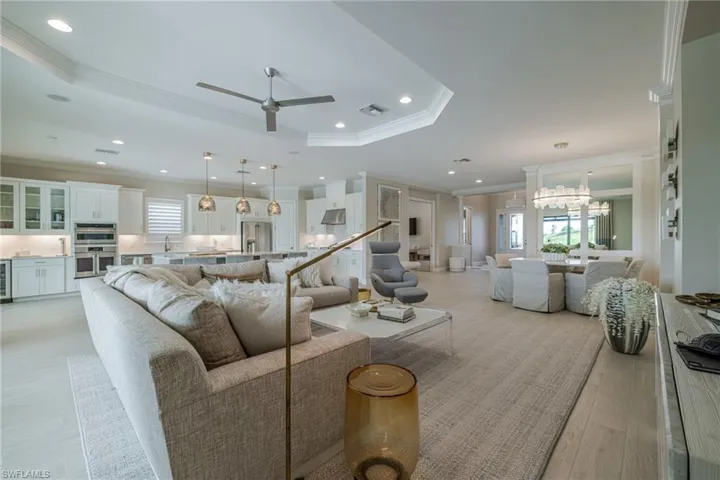 Living area featuring crown molding, a chandelier, recessed lighting, ceiling fan, and light wood-type flooring