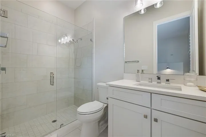 Full bath featuring a shower stall, vanity, and light tile patterned floors