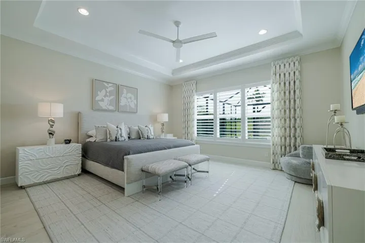 Bedroom featuring a ceiling fan, a tray ceiling, ornamental molding, and recessed lighting