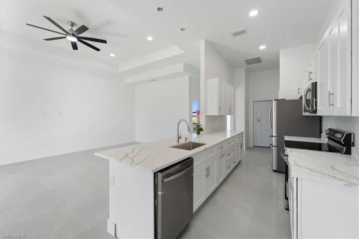 Kitchen with visible vents, stainless steel appliances, a ceiling fan, and a sink