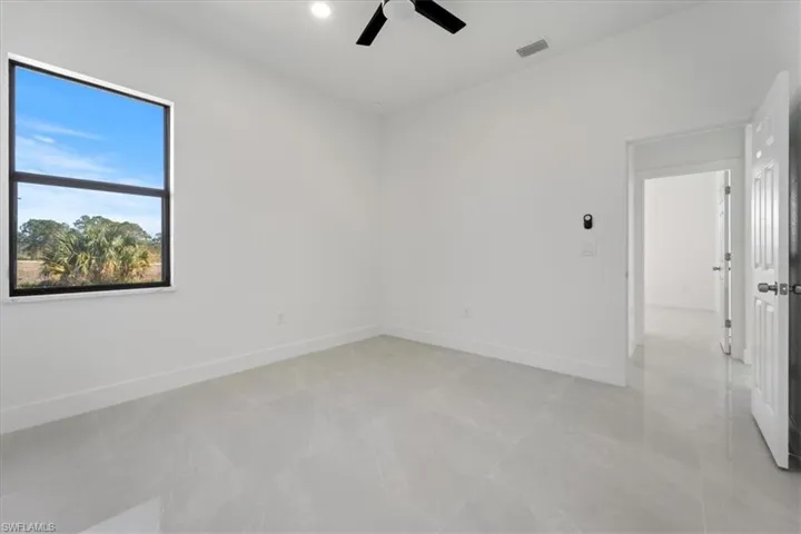 Unfurnished room featuring a ceiling fan, visible vents, and baseboards