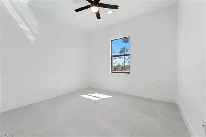 Unfurnished room featuring baseboards and ceiling fan