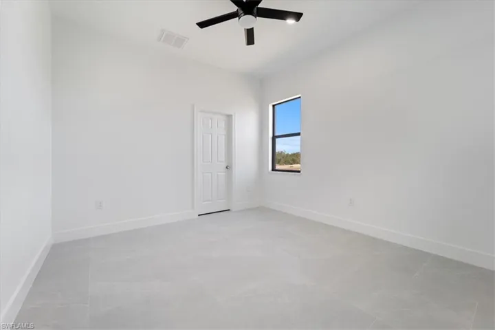 Spare room featuring visible vents, baseboards, and a ceiling fan