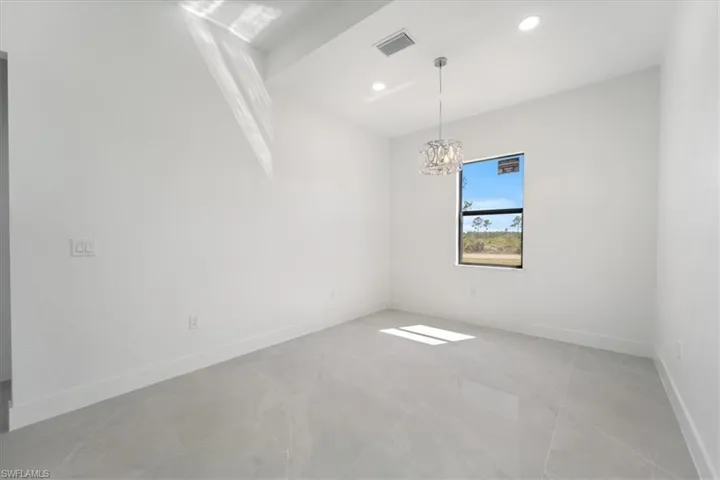 Unfurnished room featuring recessed lighting, visible vents, baseboards, and a notable chandelier