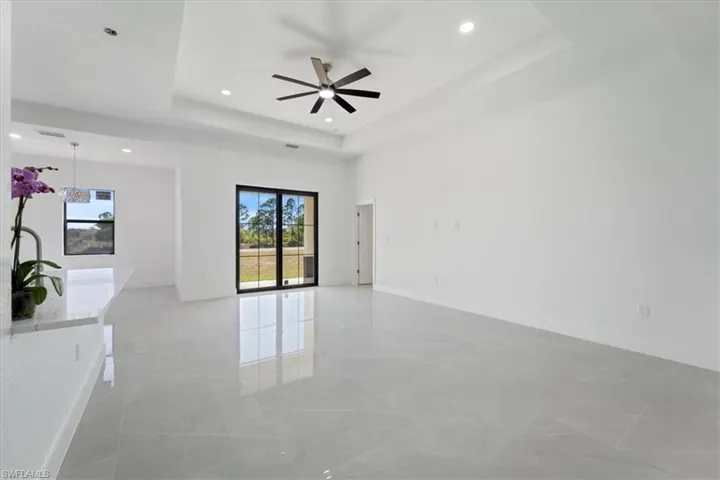 Unfurnished room with recessed lighting, a tray ceiling, baseboards, and a ceiling fan