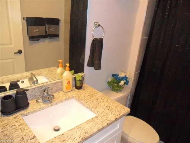 Full bathroom featuring vanity and curtained shower