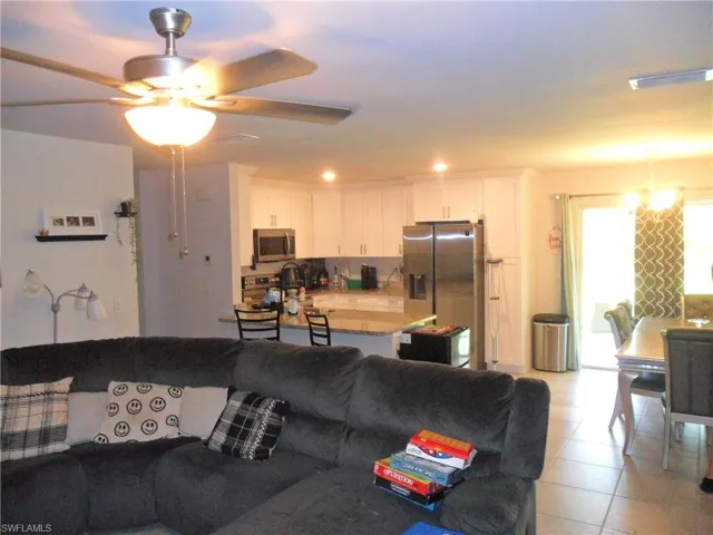 Living room featuring light tile patterned flooring and a ceiling fan